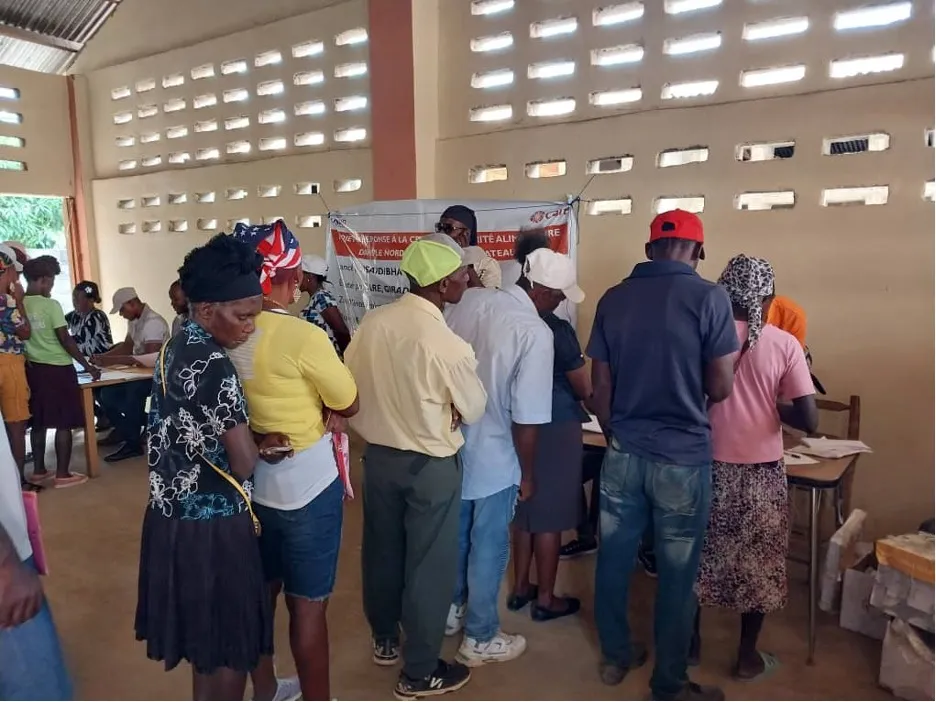 A group of people in a line leading to a table