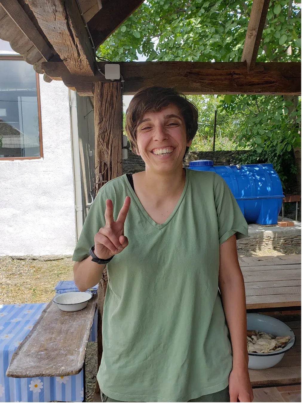 Woman in green shirt, smiling, facing camera