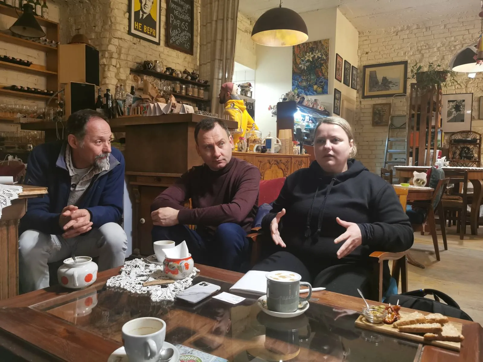 Portrait of Lyudmyla speaking to CARE staff at a coffee shop.